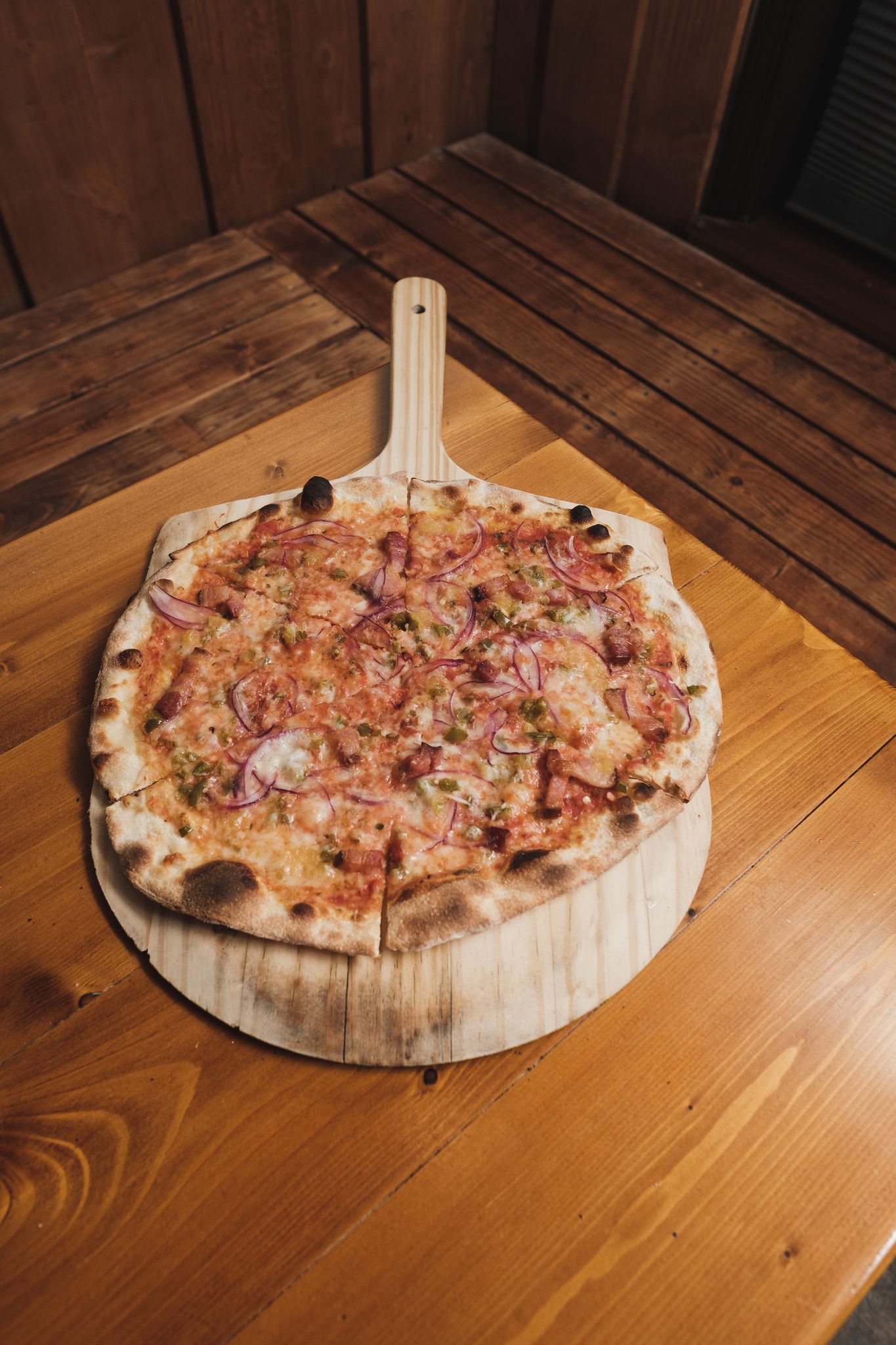A mouthwatering pizza with toppings served on a rustic wooden board, perfect for dining ambiance.